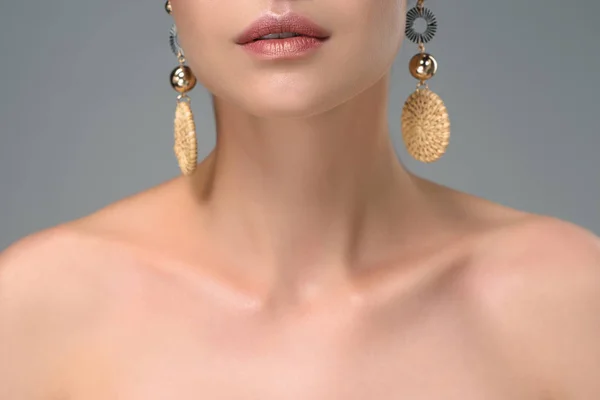 Cropped shot of naked young woman with stylish earrings isolated on grey — Stock Photo