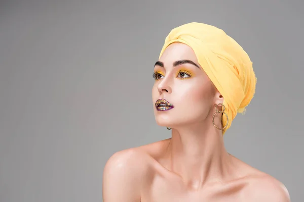 Hermosa mujer desnuda en turbante amarillo mirando hacia otro lado aislado en gris - foto de stock