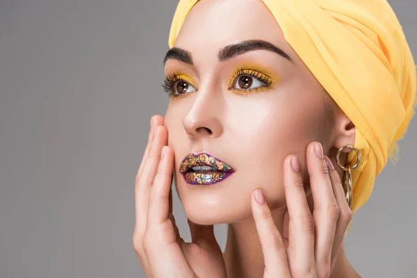 Крупным планом вид красивой женщины в желтой головной убор глядя в сторону изолированы на сером — стоковое фото
