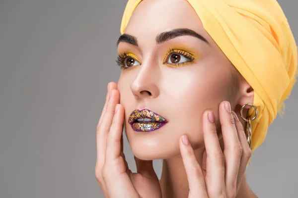 Vue rapprochée de belle femme dans une enveloppe de tête jaune regardant loin isolé sur gris — Photo de stock