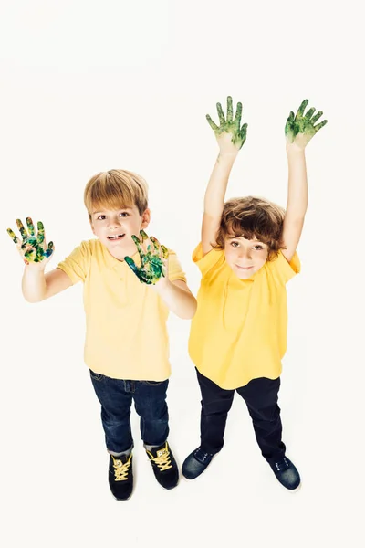 High angle view of happy little boys with hands in paint smiling at camera isolated on white — Stock Photo