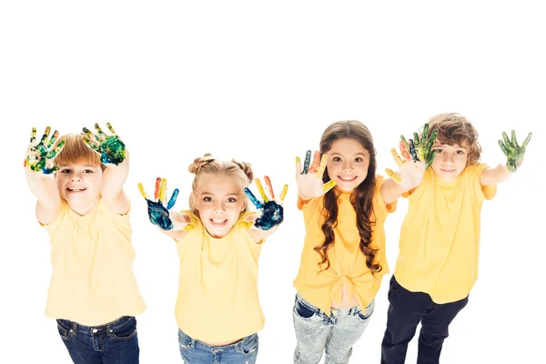 High angle view of adorable happy kids showing hands in paint and smiling at camera isolated on white — Stock Photo