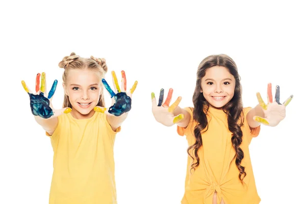 Schöne glückliche Kinder, die bunt bemalte Hände zeigen und isoliert auf weiß in die Kamera lächeln — Stockfoto
