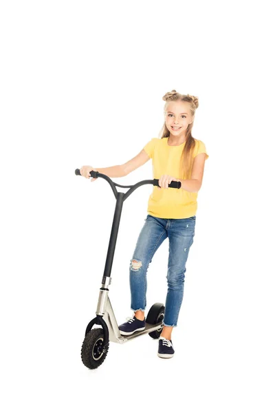 Bela criança feliz de pé com scooter e sorrindo para a câmera isolada no branco — Fotografia de Stock