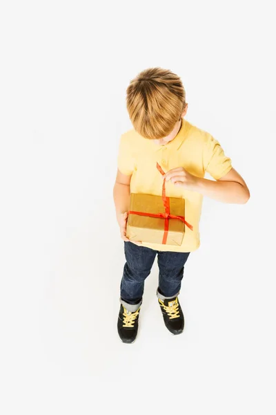 Vista ad alto angolo di adorabile bambino apertura regalo scatola isolata su bianco — Foto stock