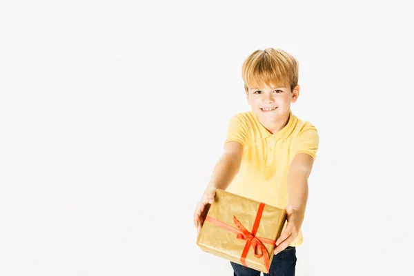 High angle view of adorable boy holding gift box and smiling at camera isolated on white — Stock Photo