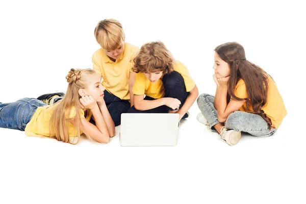 Grupo de niños adorables usando el ordenador portátil juntos aislados en blanco - foto de stock