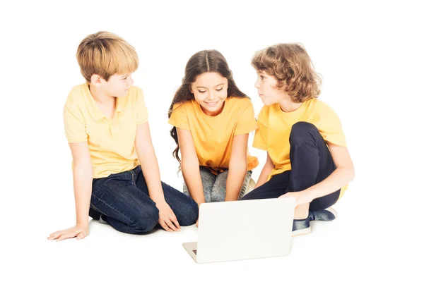 Mignon souriant enfants en utilisant ordinateur portable ensemble isolé sur blanc — Photo de stock