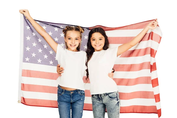 Cheerful adorable kids standing under american flag and looking at camera isolated on white — Stock Photo