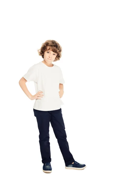 Irritierter Junge steht mit den Händen akimbo und schaut in die Kamera isoliert auf weiß — Stockfoto