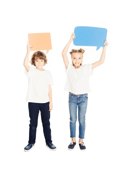 Niños adorables alegres sosteniendo burbujas del discurso del papel sobre cabezas aisladas en blanco - foto de stock