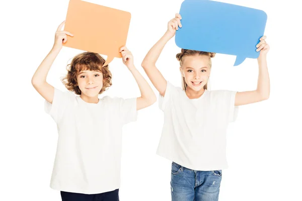 Adorables niños sonrientes sosteniendo burbujas de habla de papel sobre las cabezas aisladas en blanco - foto de stock