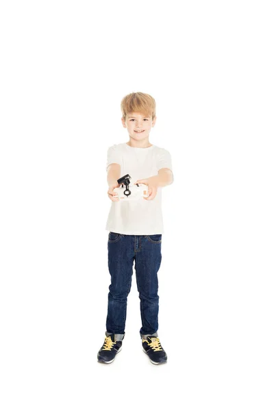 Adorable chico sosteniendo control remoto aislado en blanco y mirando a la cámara - foto de stock