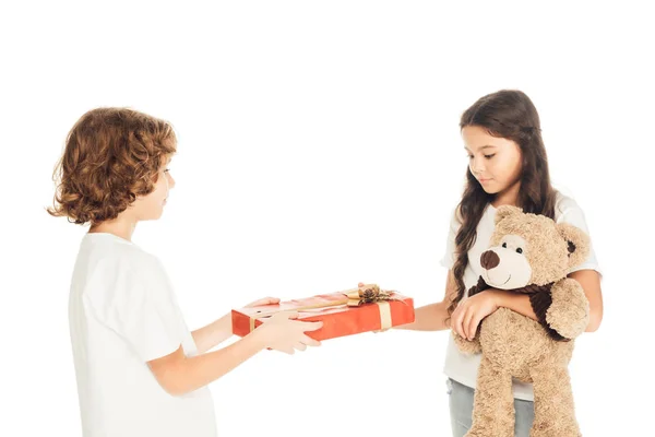 Seitenansicht des Jungen präsentiert Geschenkbox an Freund isoliert auf weiß — Stockfoto