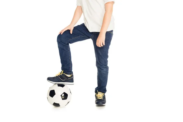 Imagem cortada de menino colocando perna na bola de futebol isolado no branco — Fotografia de Stock