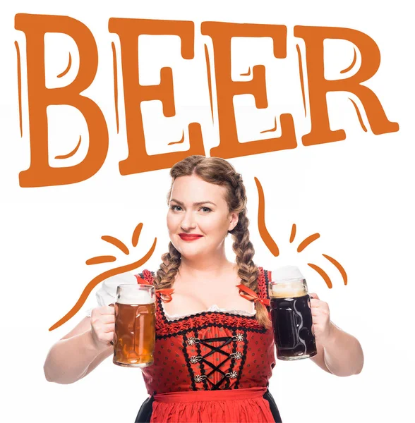 Serveuse souriante oktoberfest en robe bavaroise traditionnelle montrant des tasses à bière claire et sombre isolées sur fond blanc avec lettrage 