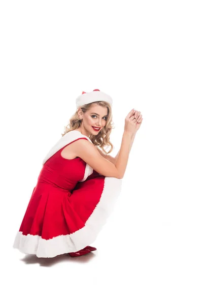 Pretty santa girl in christmas dress sitting isolated on white — Stock Photo