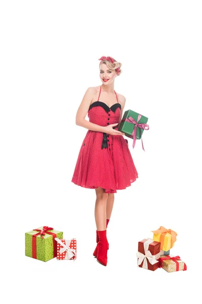 Hermosa joven pin up mujer de pie cerca de pila de cajas de regalo aislado en blanco - foto de stock