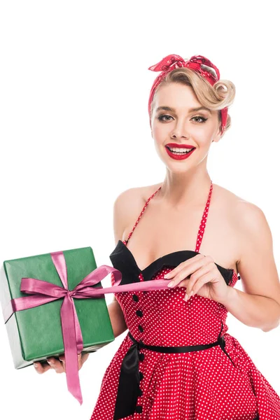 Portrait of happy young pin up woman untying gift box isolated on white — Stock Photo