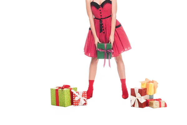 Cropped image of young pin up woman standing near pile of gift boxes isolated on white — Stock Photo