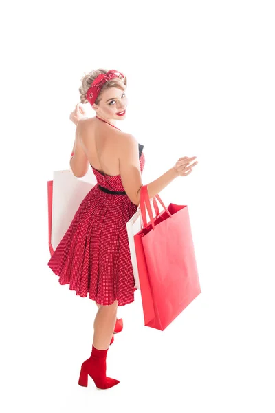 High angle view of young woman in retro pin up clothing with shopping bags isolated on white — Stock Photo