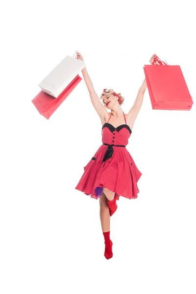 Pin up femme avec des sacs à provisions dans les mains debout sur une jambe isolée sur blanc — Photo de stock