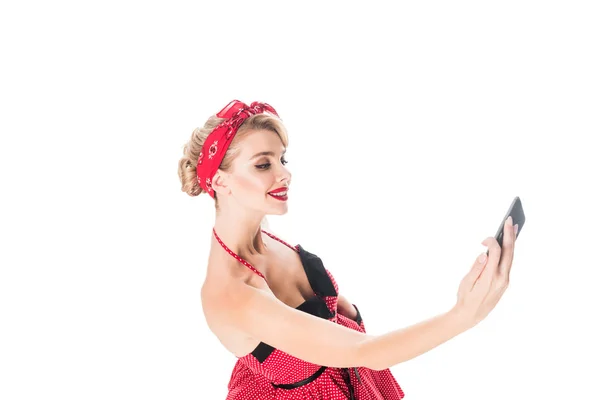 Side view of young pin up lady taking selfie on smartphone isolated on white — Stock Photo