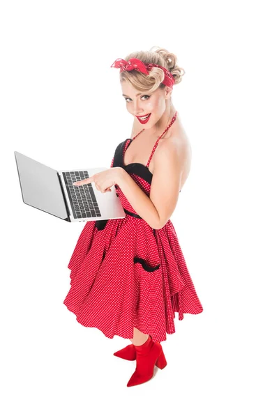 High angle view of woman in pin up style clothing pointing at laptop isolated on white — Stock Photo