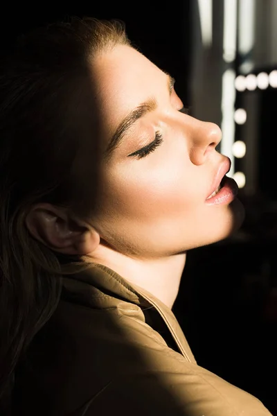 Side view of fashionable woman in trench with eyes closed — Stock Photo