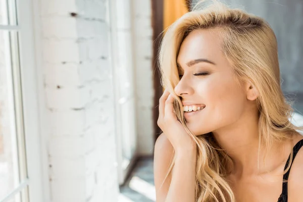 Portrait de femme attrayante souriante avec les yeux fermés dans la chambre — Photo de stock