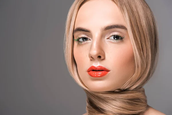 Retrato de hermosa mujer joven con el pelo largo y suave alrededor del cuello mirando a la cámara aislada en gris - foto de stock