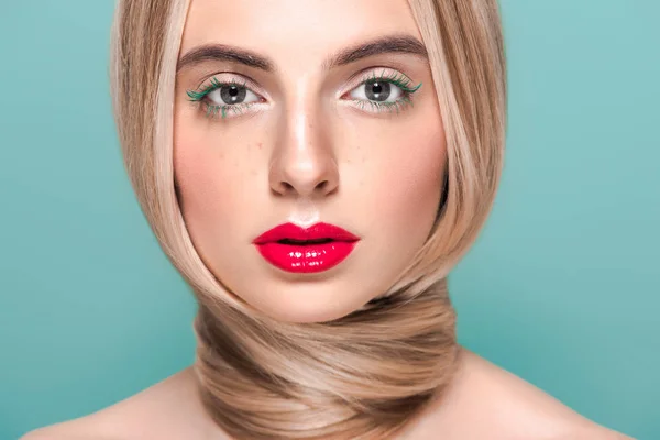 Retrato de hermosa mujer joven con maquillaje elegante y pelo largo mirando a la cámara aislada en azul - foto de stock