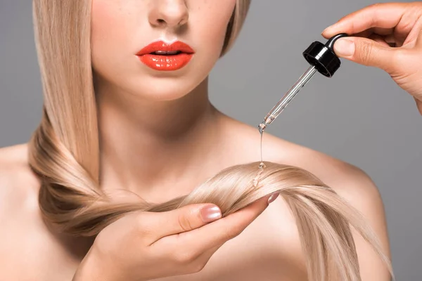 Обрізаний знімок дівчини, що отримує лікування волосся ізольовано на сірому — стокове фото