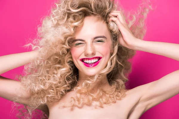 Attractive naked girl with long curly hair laughing isolated on pink — Stock Photo