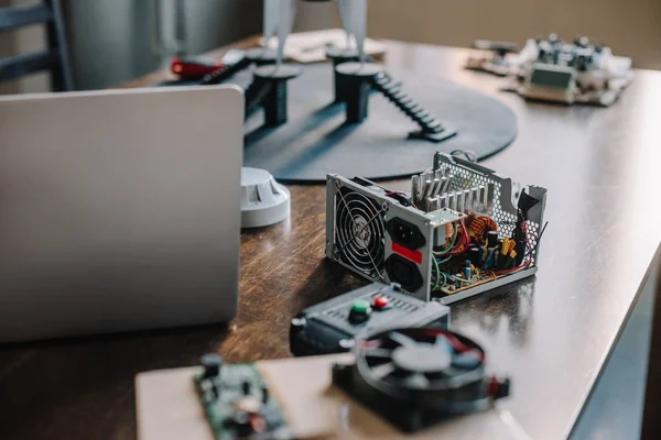 Laptop and technical parts of pc on tabletop at home — Stock Photo