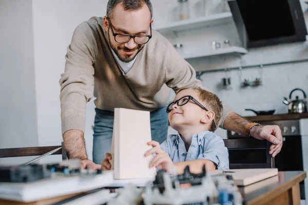 Padre e figlio sorridenti in occhiali che si guardano a casa — Foto stock