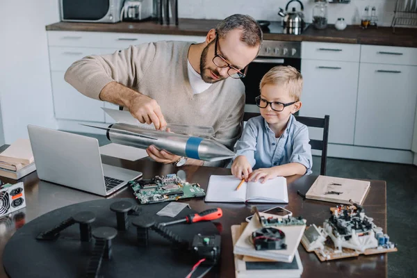 Père et fils testent ensemble le modèle de fusée à la maison — Photo de stock