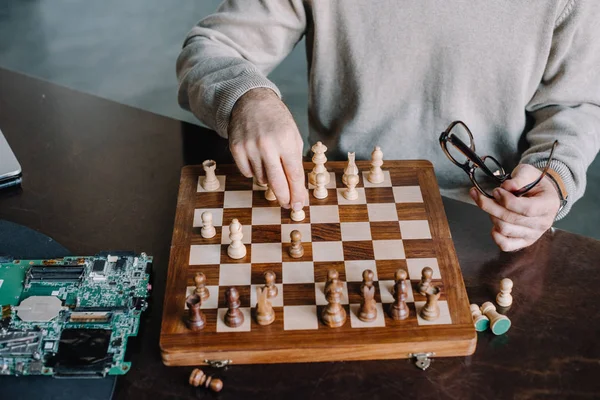 Immagine ritagliata di uomo che gioca a scacchi a casa — Foto stock