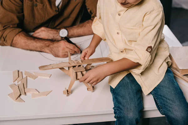 Plan recadré de père et petit fils modélisant ensemble à la maison — Photo de stock