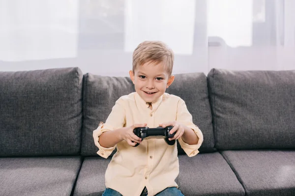 Счастливый мальчик играет с джойстиком дома — стоковое фото
