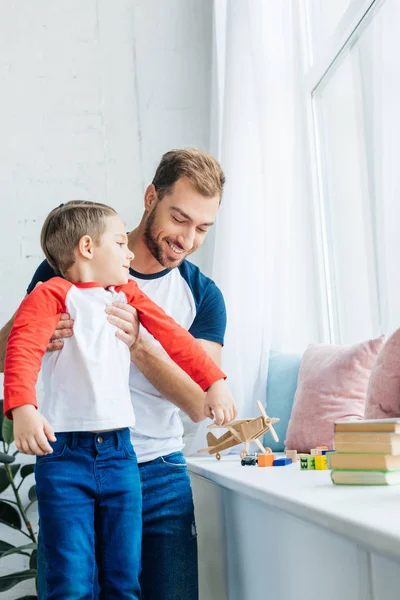 Porträt eines lächelnden Vaters, der seinen kleinen Sohn zu Hause hält — Stockfoto