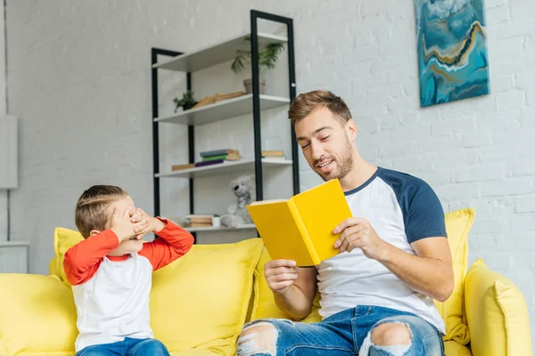 Pai livro de leitura para o pequeno filho em casa — Fotografia de Stock