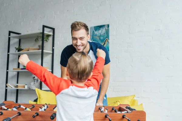Happy little boy playing table football together with father at home — Stock Photo