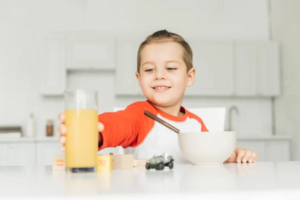 Lächelnder Junge beim Frühstück in der Küche zu Hause — Stockfoto