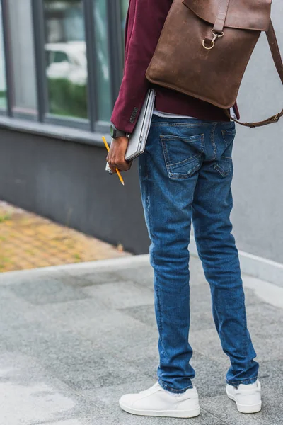 Обрізаний знімок студента з блокнотами і рюкзаком, що стоїть на вулиці — стокове фото