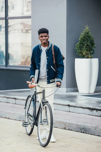 Bellissimo freelance afroamericano con documenti e bicicletta — Foto stock