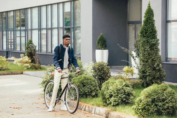 Elegante giovane uomo africano americano in bicicletta in città — Foto stock