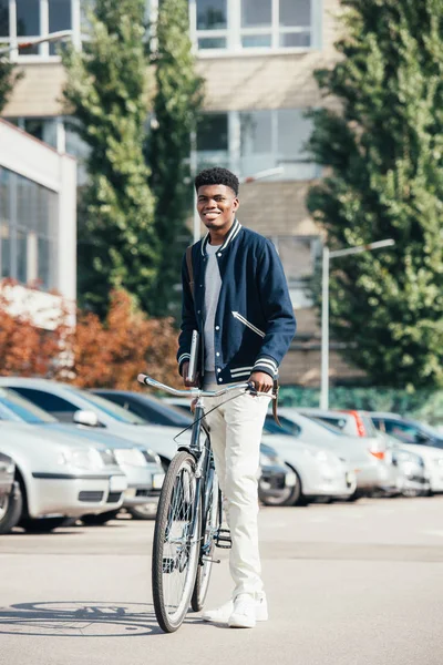 Afro-americano alegre homem elegante com bicicleta na cidade urbana — Fotografia de Stock
