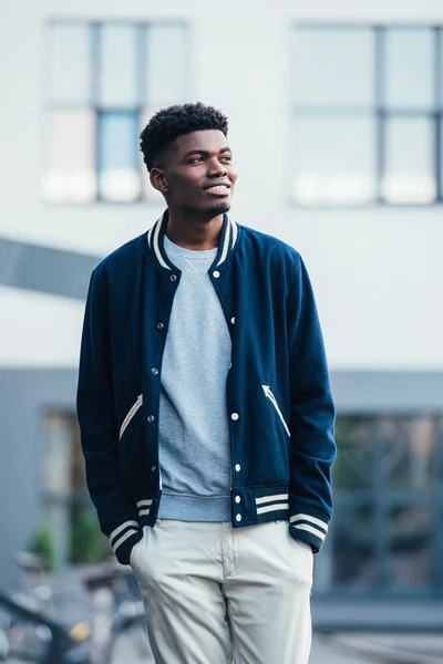 Handsome african american man in blue bomber walking in city — Stock Photo