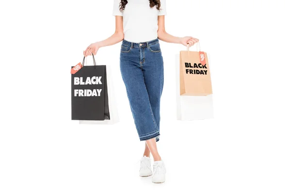 Cropped view of stylish shopper holding shopping bags with black friday sale signs isolated on white — Stock Photo